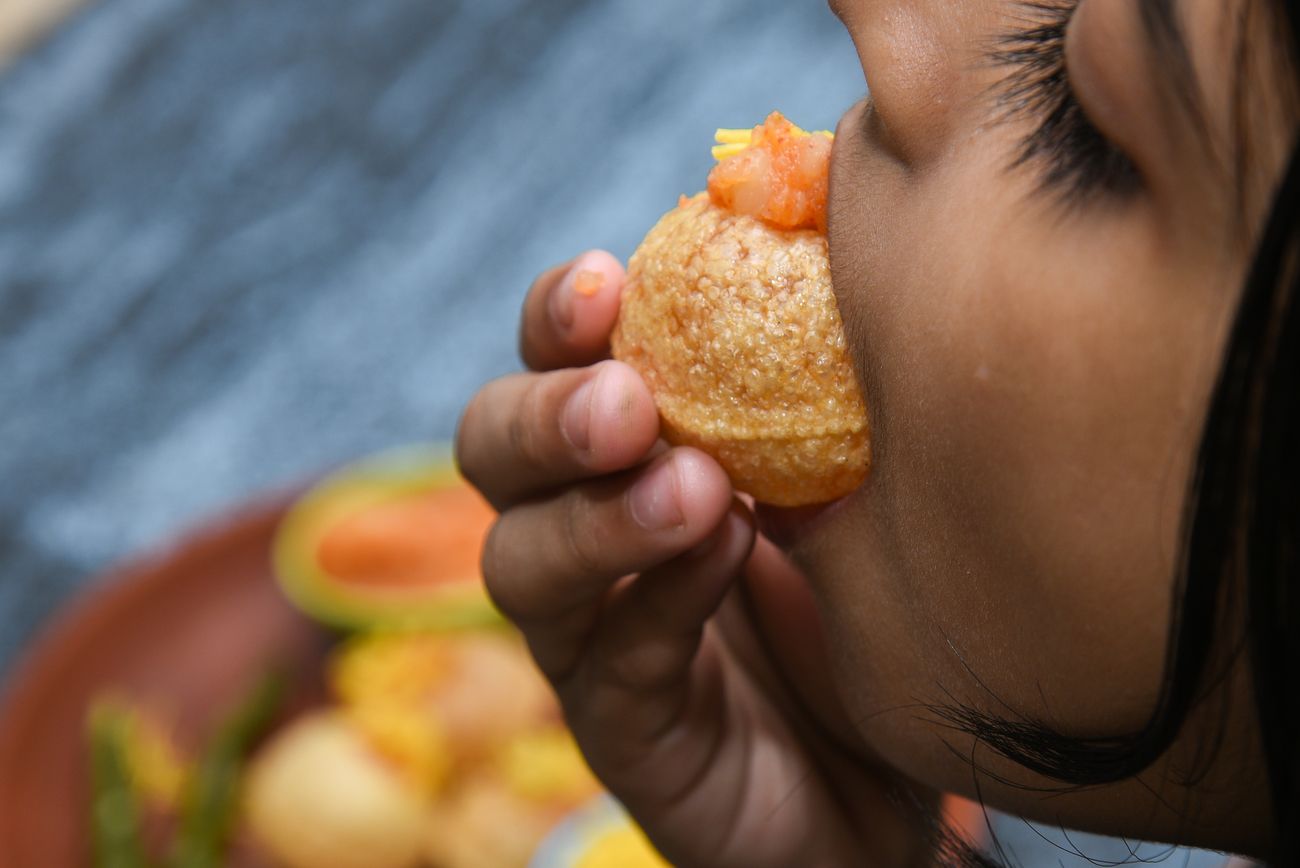 Ein junges Mädchen isst Panipuri, einen beliebten indischen Straßensnack
