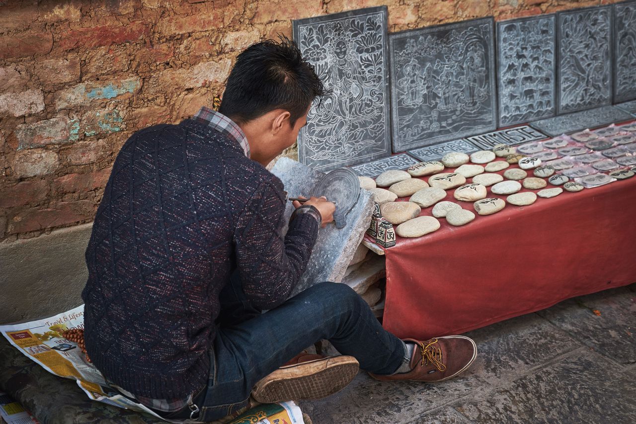 Nepalesischer Steinmetz arbeitet im Swayambhunath-Tempel